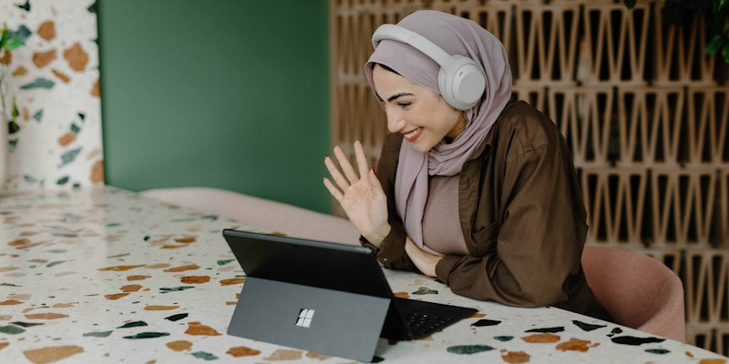 a person sitting on a table with a laptop